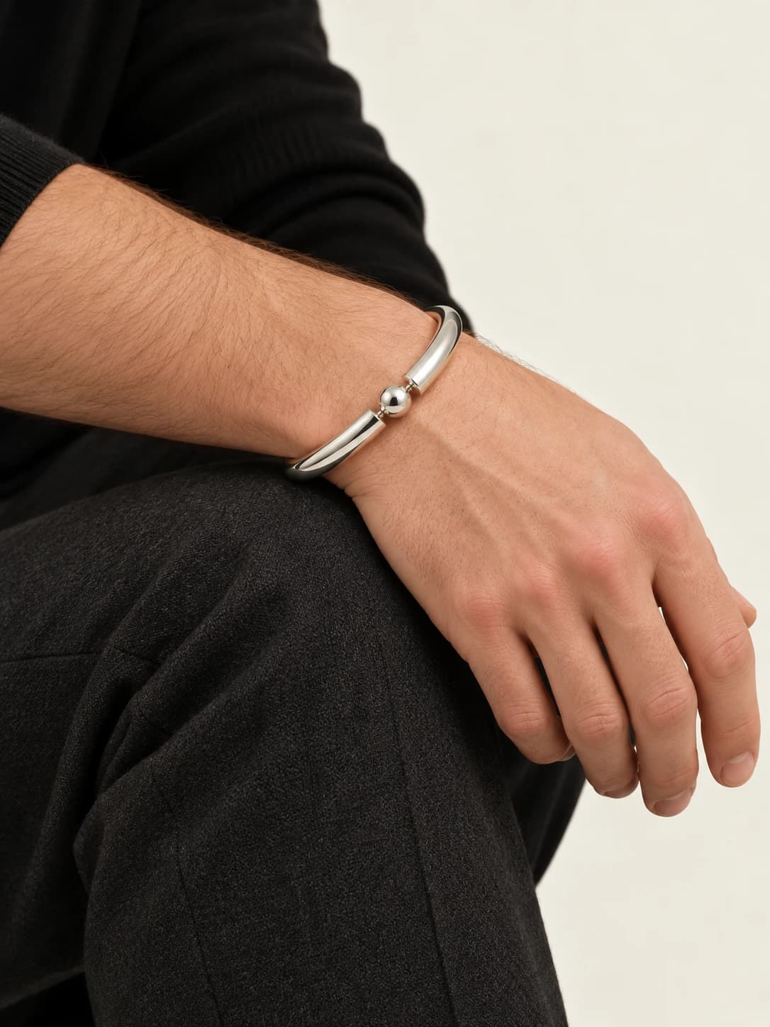 Break bangle, worn on a relaxed wrist resting across a knee